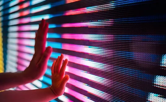 Zwei Hände berühren bunten Bildschirm, symbolisieren Digitale Transformation