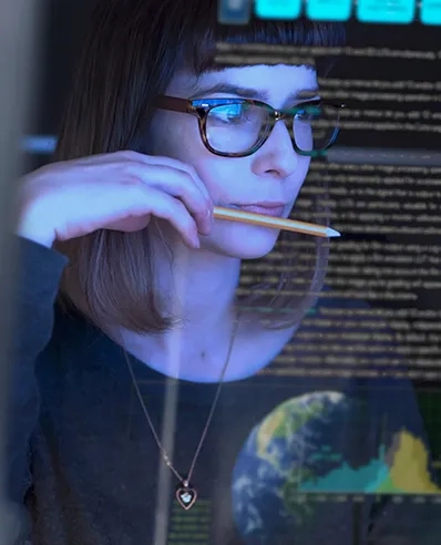 Transaction Services versinnbildlicht durch eine Frau, die Daten analysiert