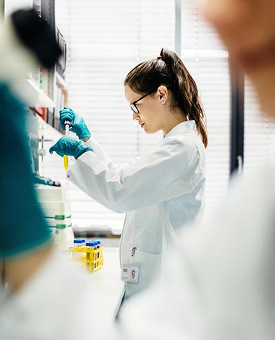 Innovative Gesundheitsversorgung durch Healthcare Consulting Services von Protiviti Frau im Labor befüllt ein Reagenzglas mit einer Pipette